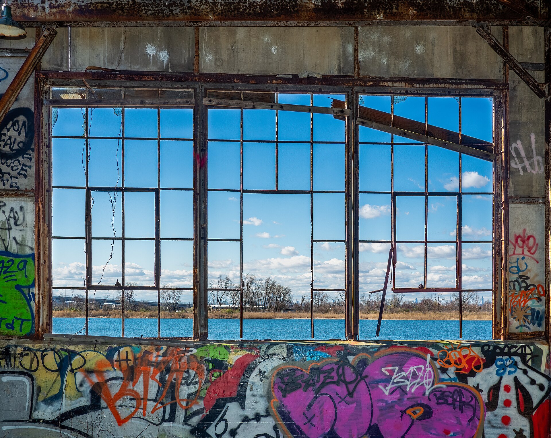 A derelict building window frames a view of water, illustrating the concept of planning a campaign timeline.