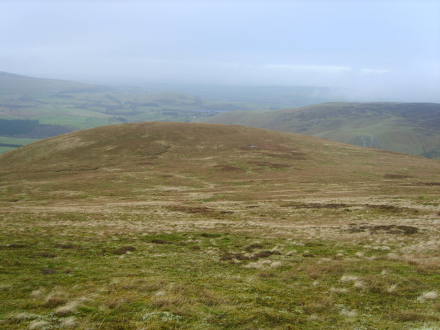 Rolling hills and grassy slopes are visible under a cloudy sky, illustrating an article about media relations.